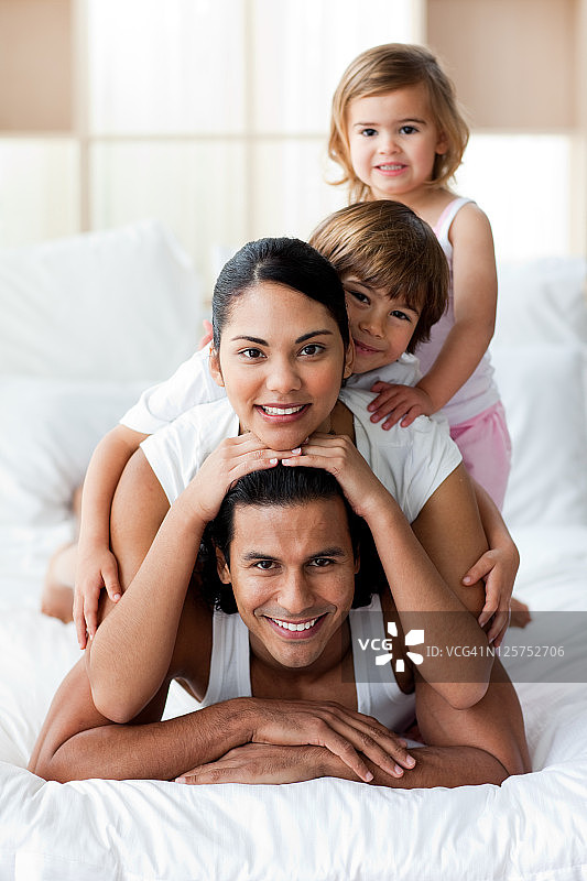 年轻的家庭在床上玩得很开心图片素材