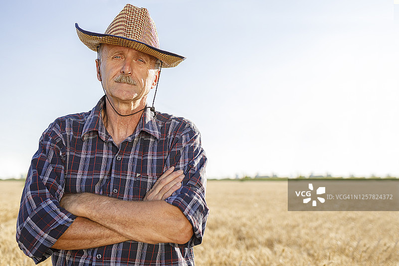 一个戴着草帽的农民站在地里图片素材
