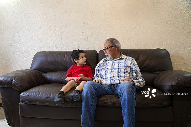 爷爷和孩子坐在家里的沙发上图片素材