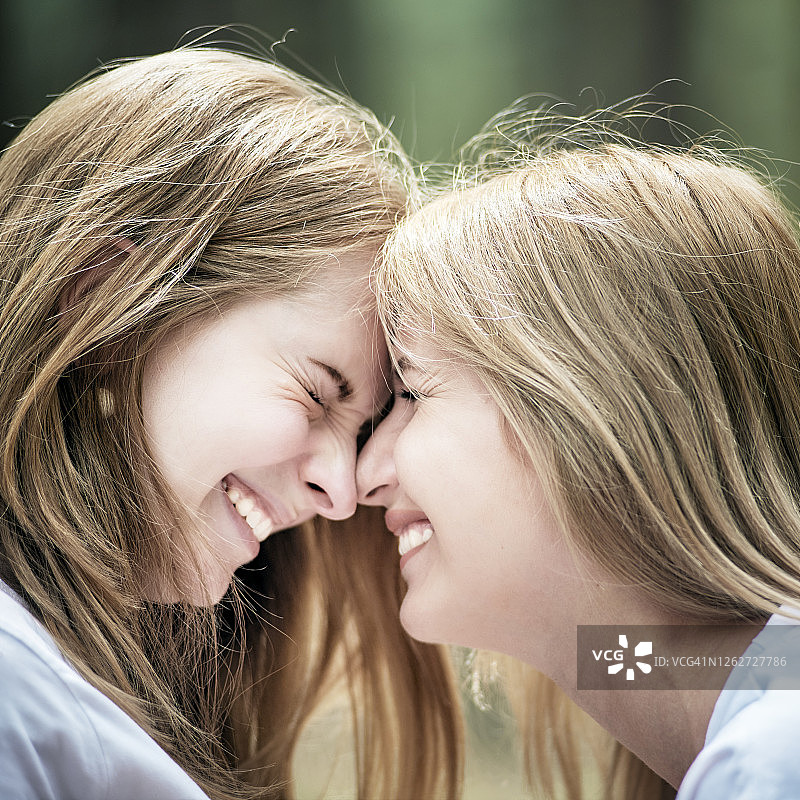 两个微笑的年轻女人的肖像，侧视图图片素材