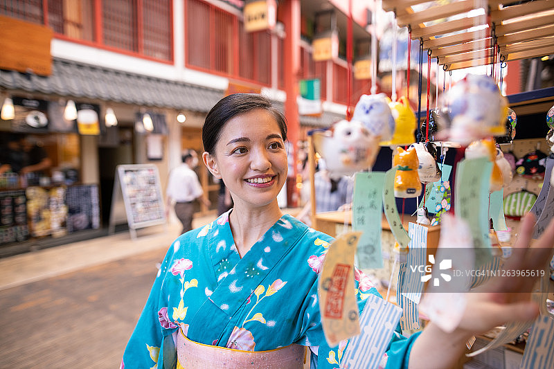 年轻女子在yukata购物在日本'福林'野生编钟商店图片素材
