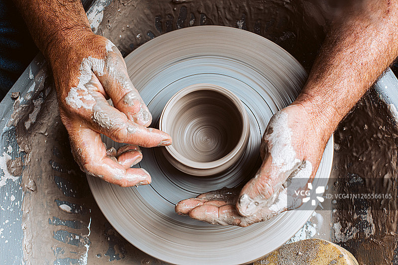 陶工的双手在陶工轮上制作粘土图片素材