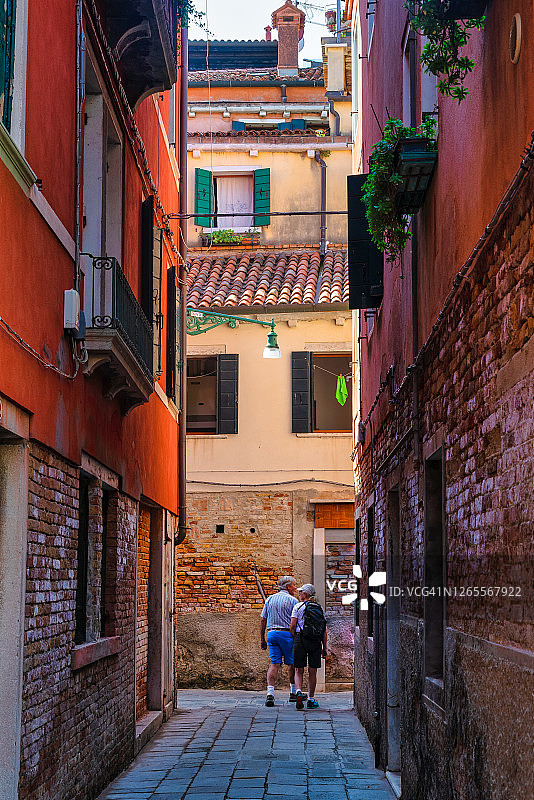 一对情侣在意大利威尼托威尼斯狭窄的街道上散步图片素材