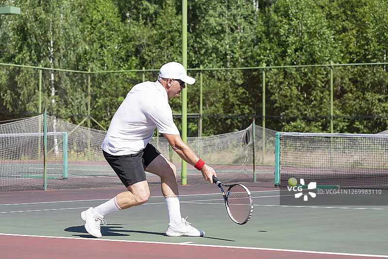 一位老人在室外打网球图片素材