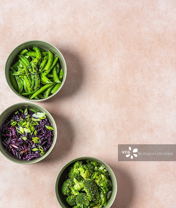 粉色背景的沙拉碗(红卷心菜、花椰菜和糖豌豆)图片素材