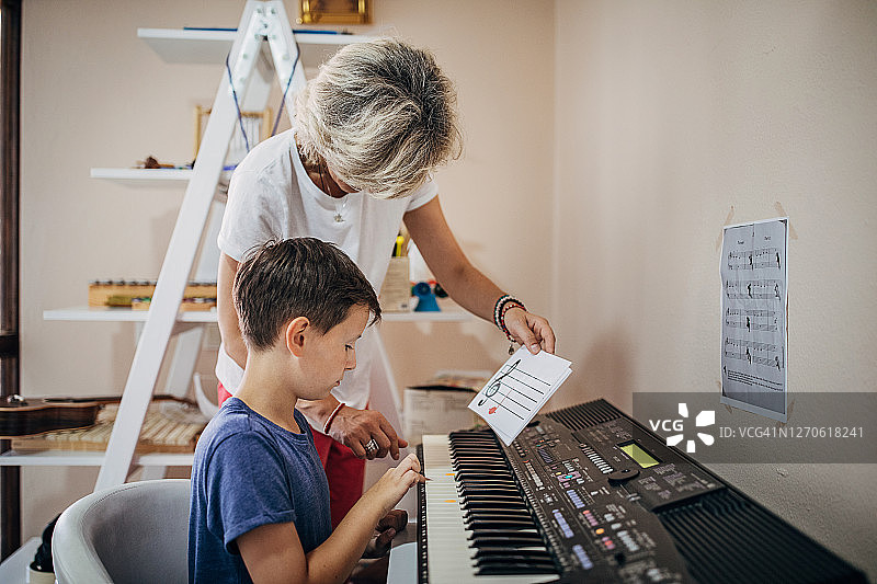 在儿童发展中心，小男孩和他的音乐老师一起学习如何玩合成器图片素材