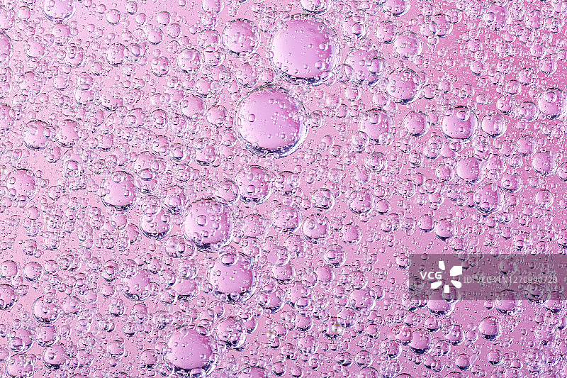 油与泡沫在珊瑚的背景。粉色抽象空间背景。软选择聚焦。油滴在水面的宏观。副本的空间。水中的气泡图片素材