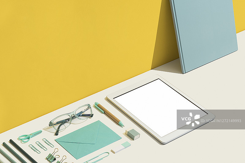 蓝色办公用品，黄白色背景，数码平板电脑图片素材