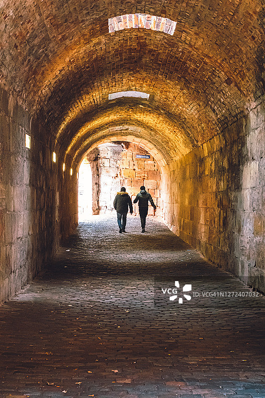 游客后视图行走在隧道在纽伦堡市，德国，欧洲图片素材