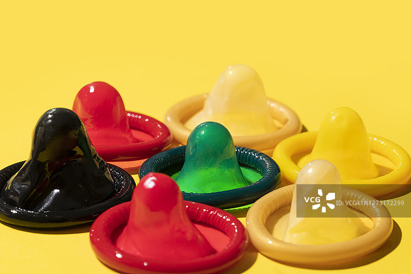 黄色背景上的多色避孕套图片素材