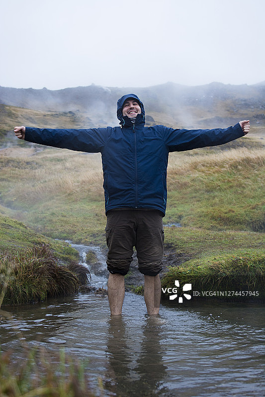 一名男子站在冰岛雷克雅达鲁尔的温泉里图片素材
