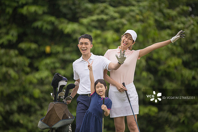 亚洲华人家庭高尔夫球手与女儿在高尔夫球场上玩得很开心图片素材