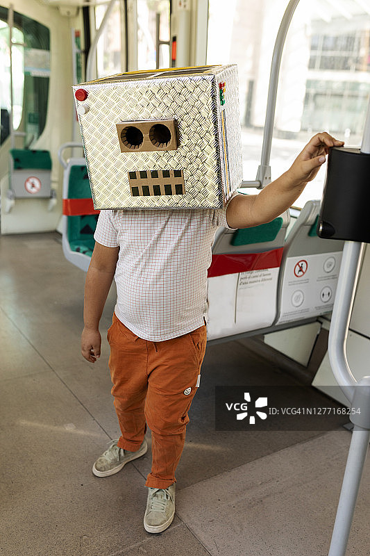 穿着机器人服装的男孩站在火车上图片素材
