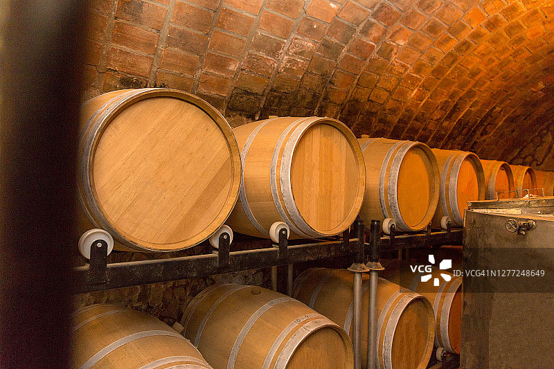 酒桶堆放在酿酒厂的老地窖里。图片素材