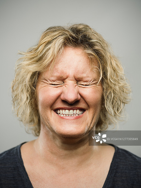 一个真实的白人成年妇女的肖像与兴奋的表情和闭上眼睛图片素材