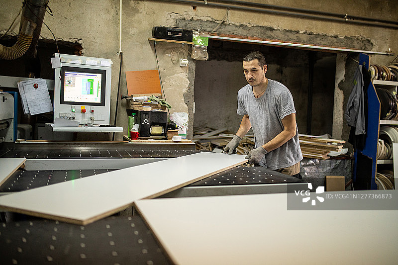 在木工公司手工工人使用数控机床进行木材加工图片素材