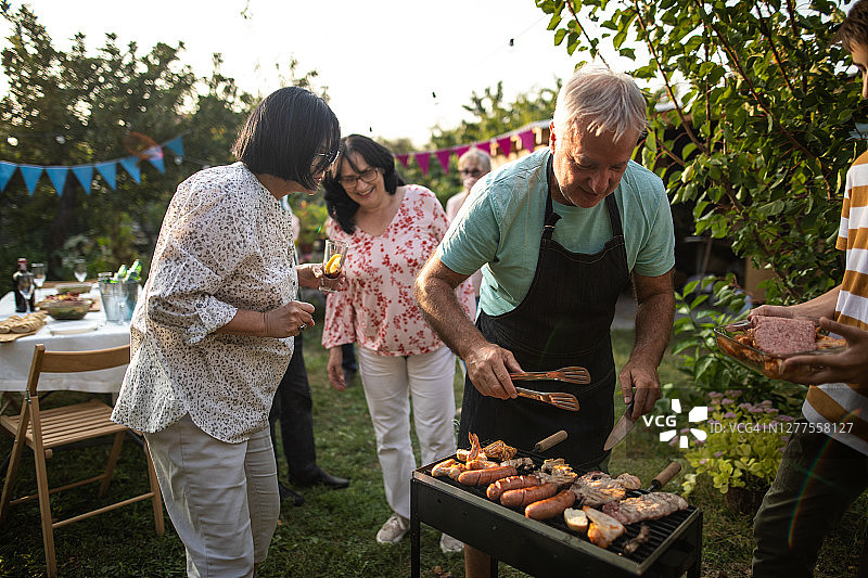 爷爷和孙子在后院聚会前一起烤肉图片素材