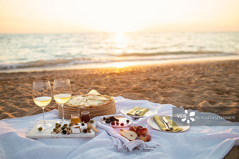 美丽的野餐在海边日落。图片素材