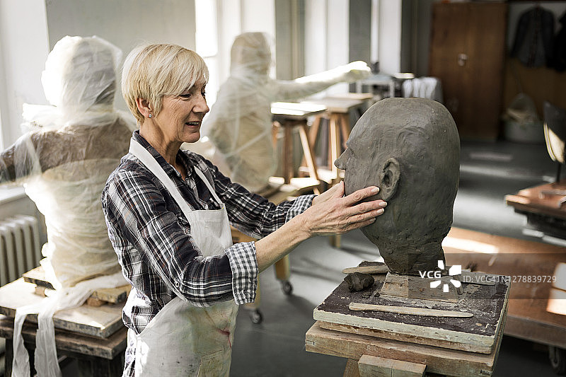 高级女性雕刻家在泥塑半身像图片素材