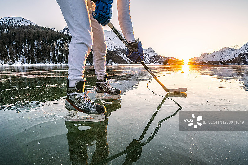 瑞士锡尔斯湖，一名男子穿着冰鞋在打冰球图片素材