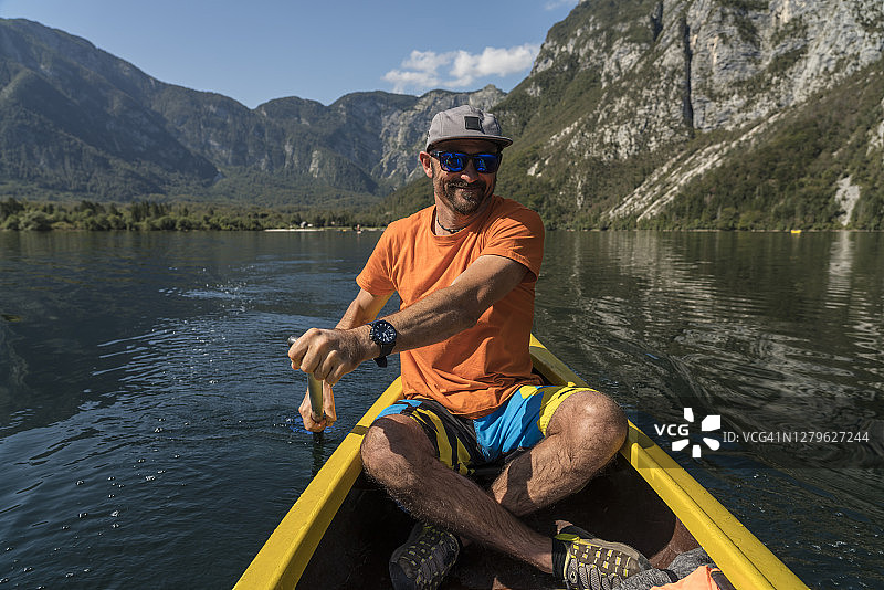 英俊的男人在博欣湖划着独木舟图片素材