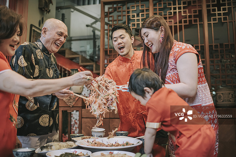 亚洲华人家庭农历新年团圆饭吃传统菜肴生鱼刘生怡生图片素材