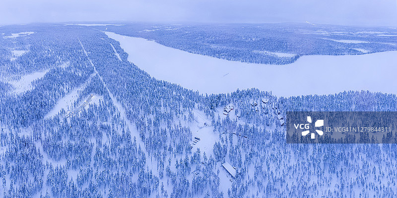 在芬兰拉普兰北极圈的托拉西皮，无人机拍摄的森林里的小屋、小屋和住宿，冬天的景色和树林里的树木图片素材
