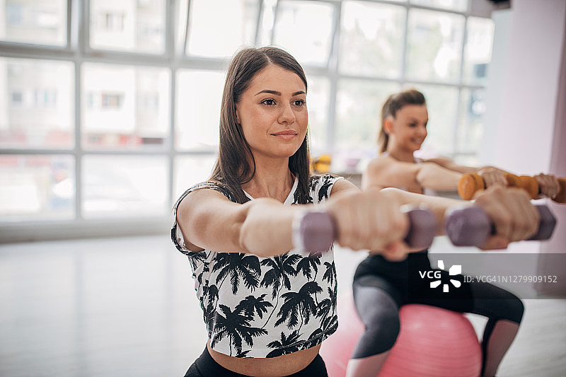 两个年轻女人在健身房一起锻炼图片素材