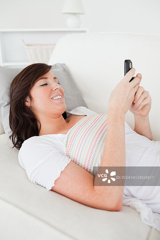 漂亮的黑发女子正在用手机发短信图片素材