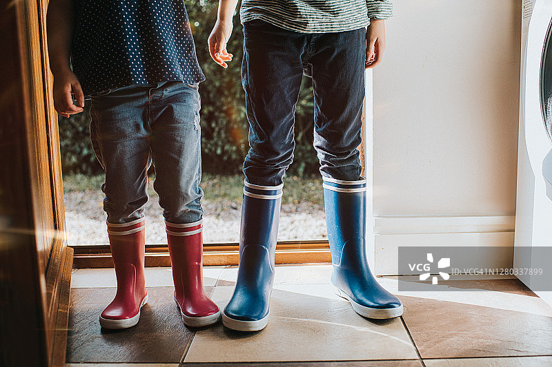 一个男孩和一个女孩穿着雨靴在杂物间图片素材