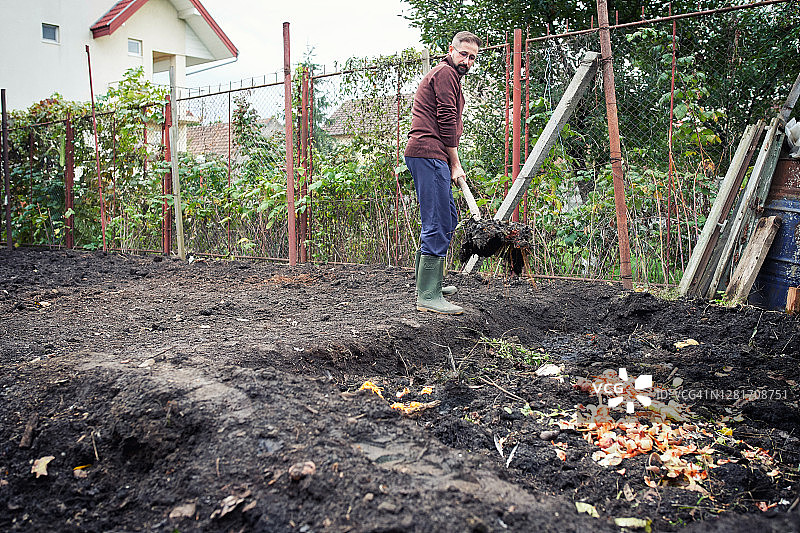 农民在花园里整理水果和蔬菜的生活垃圾。图片素材