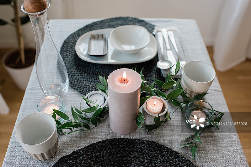 在家里为两人准备的浪漫餐桌上放着一根大蜡烛图片素材