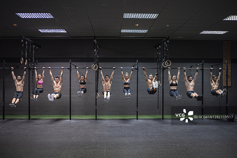 男性和女性运动员在健身房的杆子上图片素材