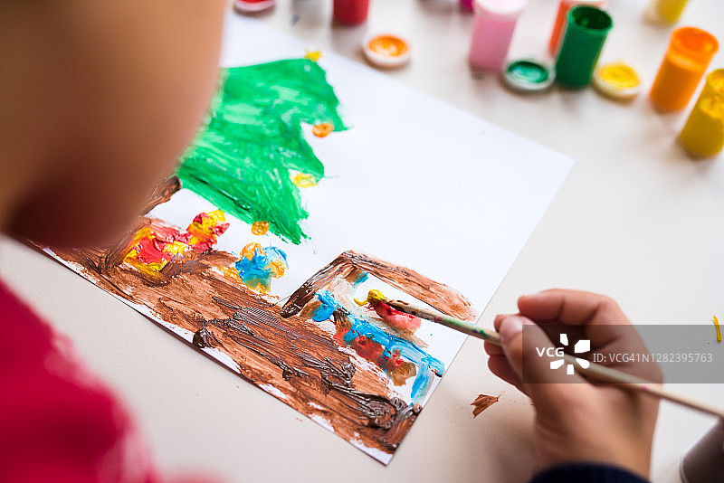 小男孩用彩色颜料在一张白纸上画了一棵圣诞树图片素材