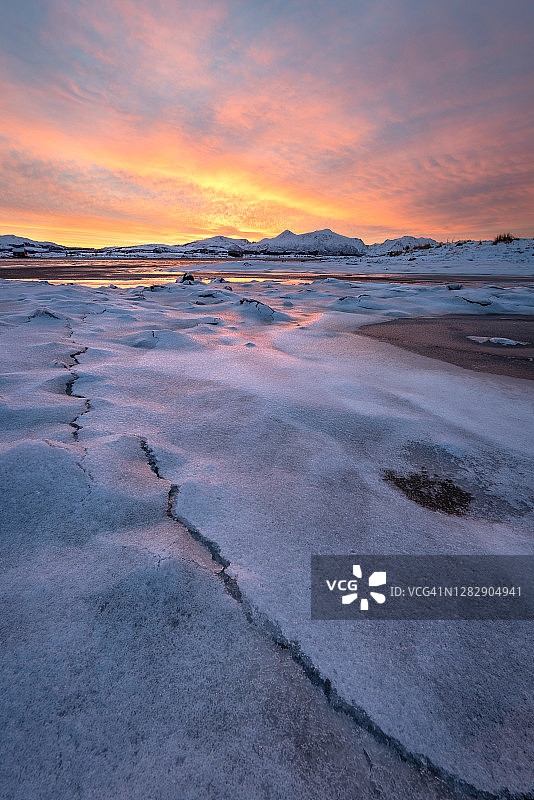 在挪威，冬日的冰冻景观在一个色彩缤纷的日出图片素材