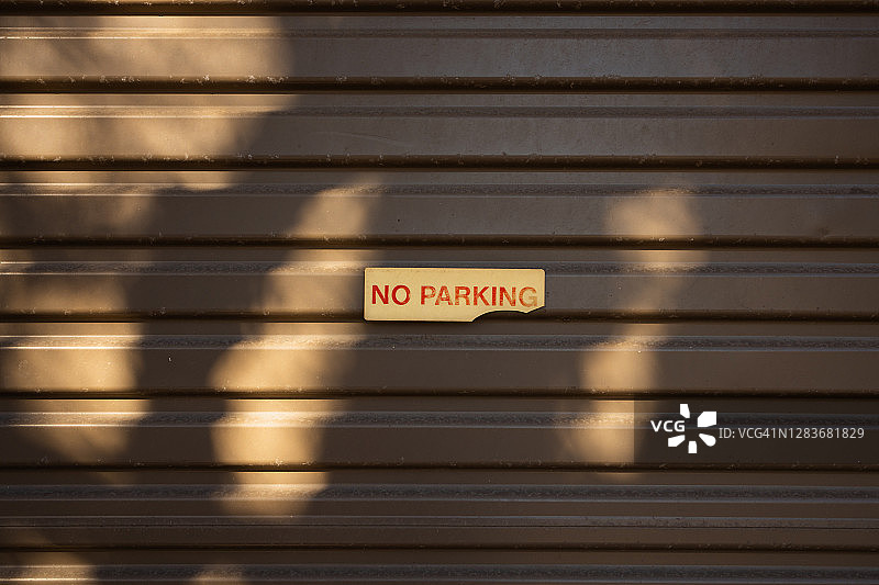 旧车库门上的“禁止停车”标志褪色图片素材