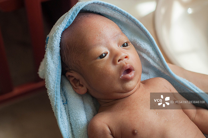 一名东南亚男婴洗澡后裹着毛巾图片素材