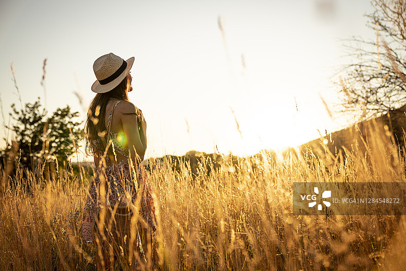 一个年轻女子的肖像在一个日落的田野图片素材