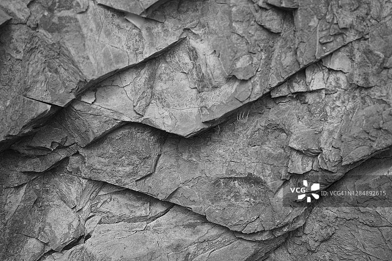 黑白色的岩石背景。石质石的表面纹理。灰色的背景。乏味的东西。图片素材