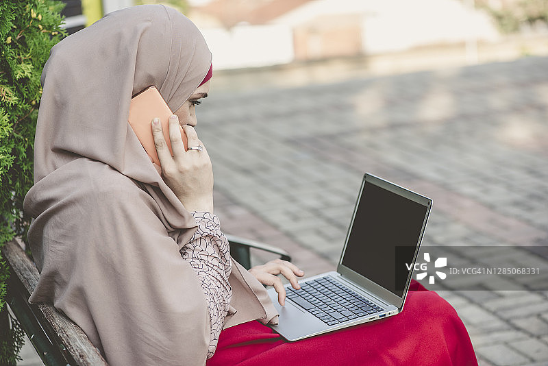 年轻的穆斯林妇女使用笔记本电脑图片素材