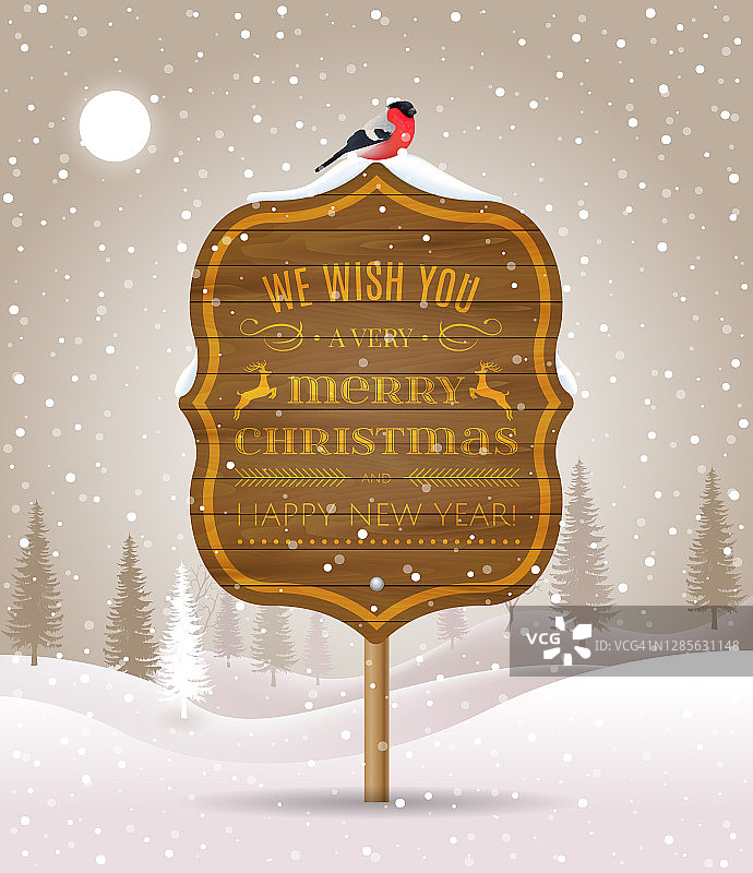 木制的告示牌上写着圣诞祝福，冬天的风景是白雪覆盖的森林和红腹灰雀。假日冬季景观背景与冬季树。圣诞快乐，恭贺新禧。图片素材