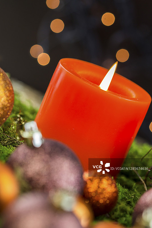 燃烧着红色的圣诞蜡烛和棕色和铜主题的圣诞装饰品图片素材