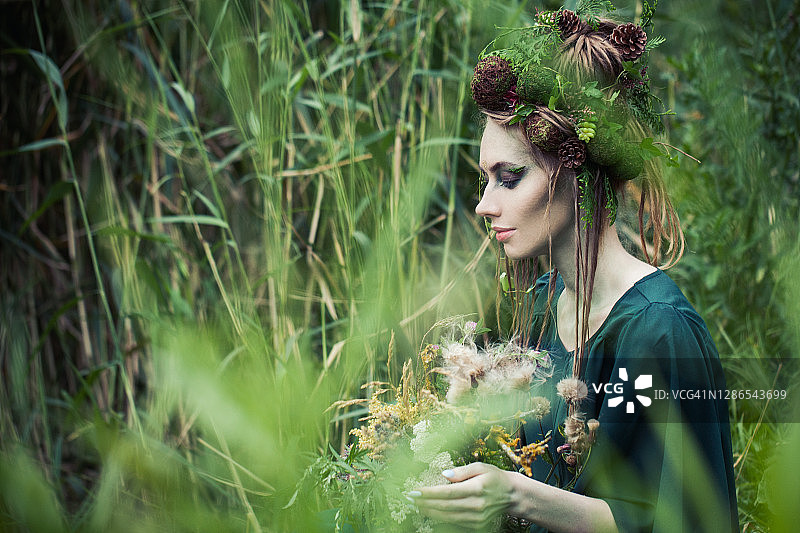 美丽的女人地球仙女在绿草的背景户外图片素材