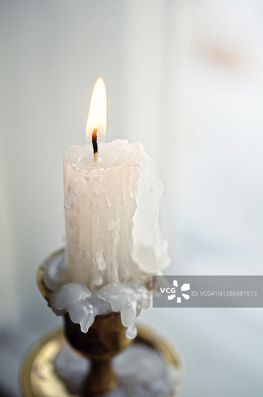 静物与燃烧的白色仙女蜡烛侧视图在一个明亮的冬季室内在一个窗口背景关闭图片素材