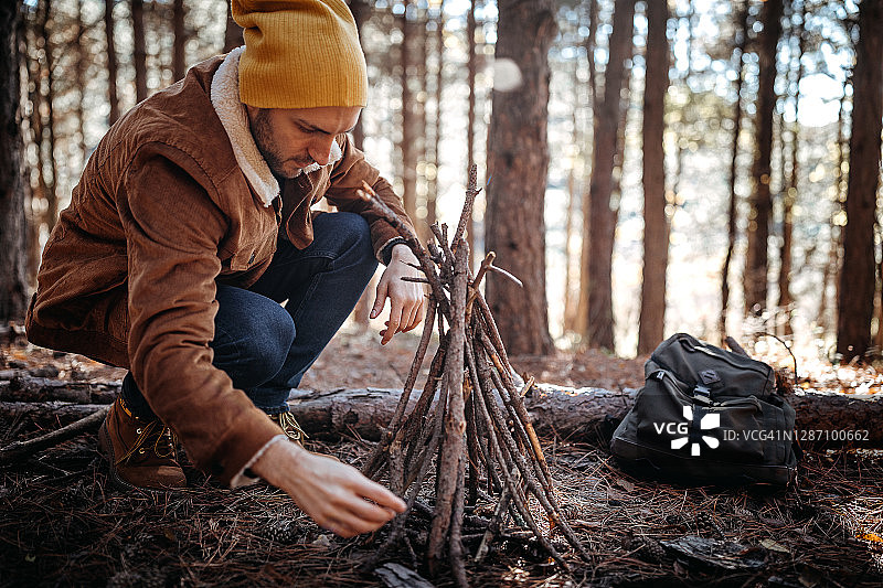 一个年轻人在森林露营时准备生火图片素材