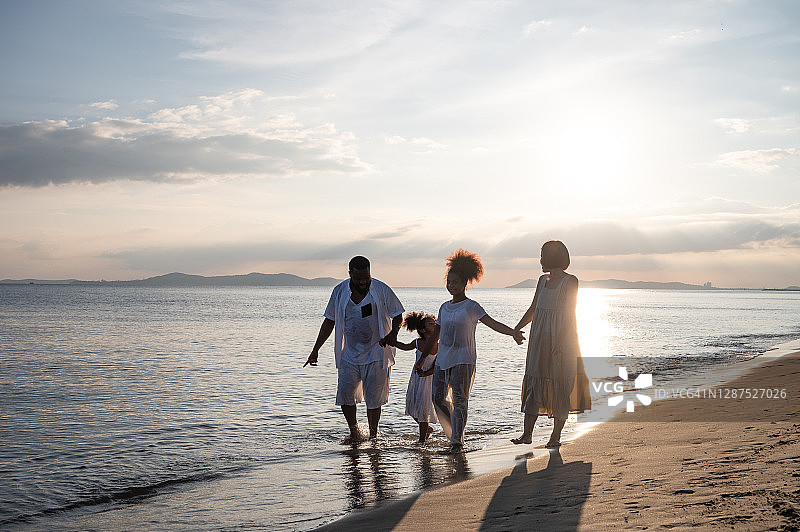 一个非裔美国混血家庭正走在海滩上图片素材