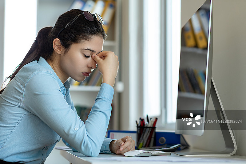 压力大的女性在工作中感到头痛图片素材