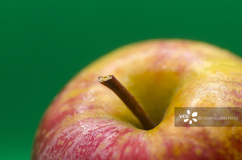 红苹果对绿色背景的特写图片素材
