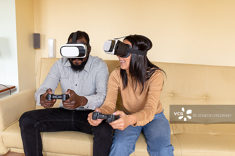 快活的非洲青年男女正在用VR眼镜和手柄玩电子游戏。虚拟现实已经成为现实。图片素材