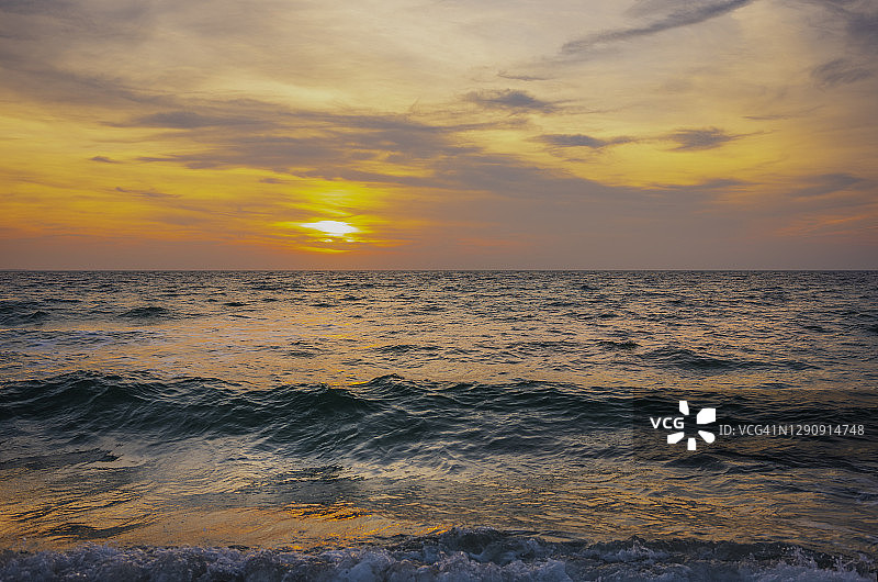 日落海景与戏剧性的云和潮汐波在科德角图片素材